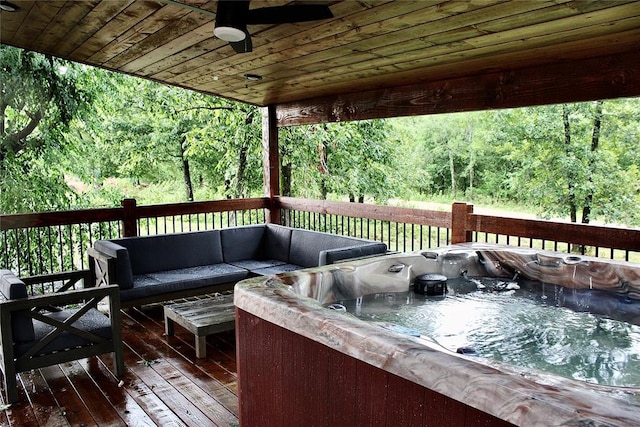 wooden terrace featuring an outdoor hangout area, a hot tub, and ceiling fan