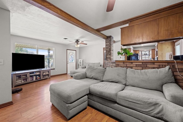 living room featuring ceiling fan, beam ceiling, and light hardwood / wood-style flooring