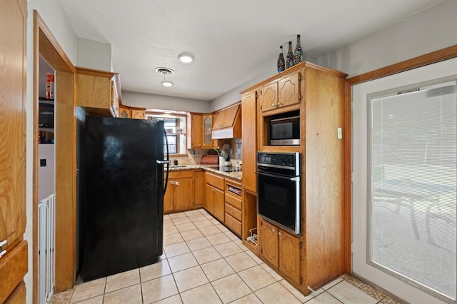 kitchen featuring light tile patterned flooring, black appliances, and custom exhaust hood