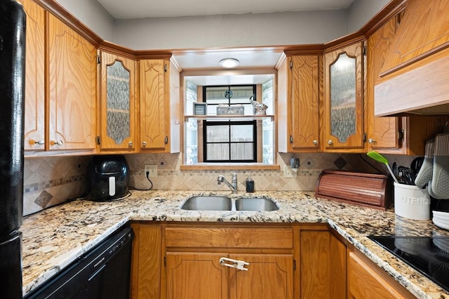 kitchen with black appliances, light stone countertops, sink, and tasteful backsplash