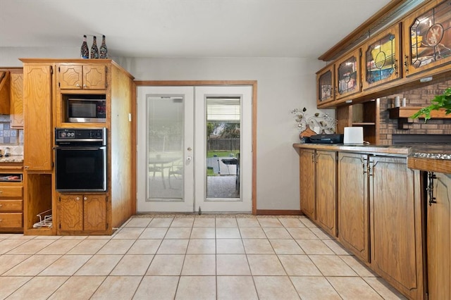 kitchen featuring black oven, french doors, and light tile patterned flooring