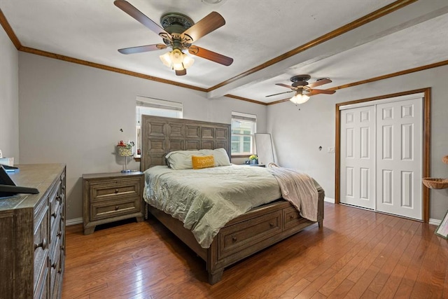 bedroom with wood-type flooring, a closet, ceiling fan, and ornamental molding