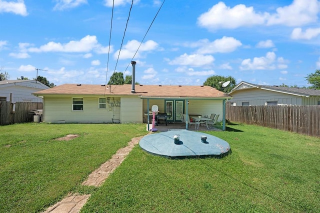 rear view of property featuring a lawn and a patio