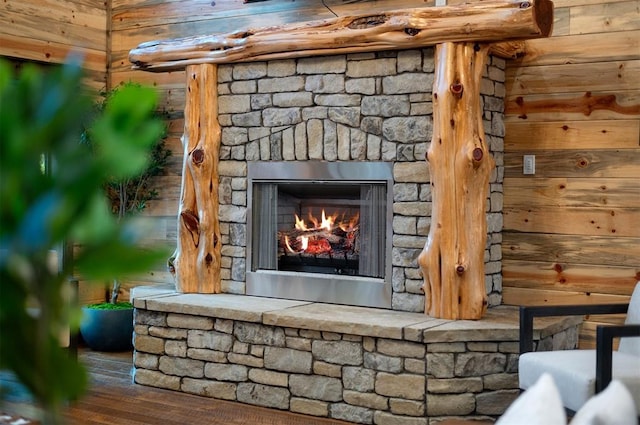 details with hardwood / wood-style floors, a stone fireplace, and wood walls