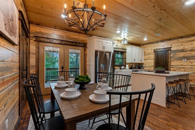 dining space with french doors, wood ceiling, dark hardwood / wood-style floors, wooden walls, and a notable chandelier