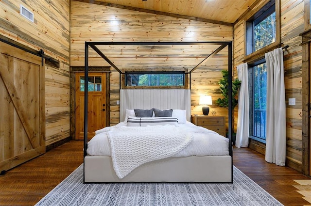 bedroom featuring dark wood-type flooring, wooden walls, wooden ceiling, and a barn door