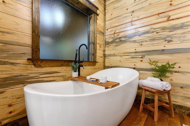 bathroom featuring a tub to relax in and wood walls