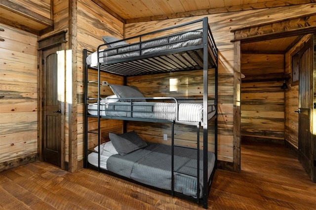 unfurnished bedroom featuring wood ceiling, wooden walls, and hardwood / wood-style flooring