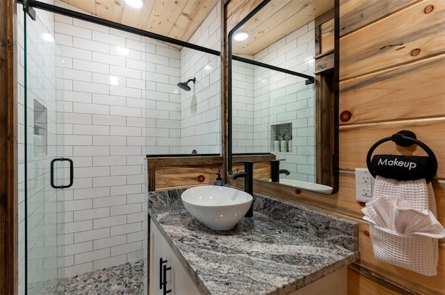 bathroom featuring vanity, tile walls, and a shower with shower door