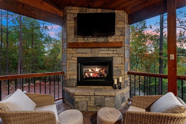 wooden terrace featuring an outdoor stone fireplace