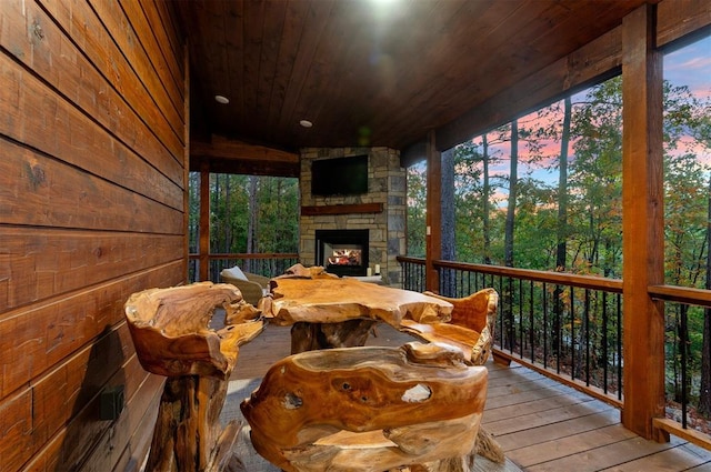 sunroom / solarium featuring wood ceiling, vaulted ceiling, and an outdoor stone fireplace