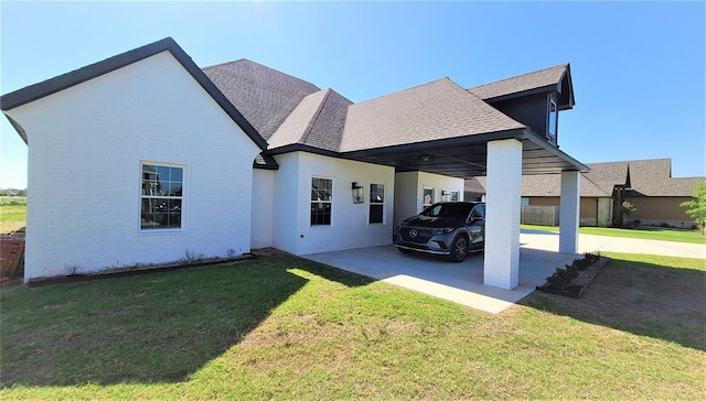 view of side of property with a carport and a yard