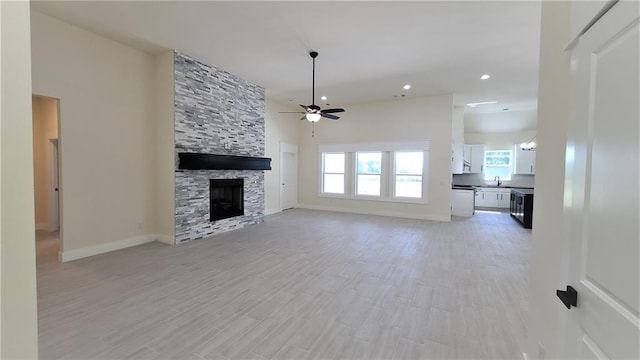 unfurnished living room featuring a wealth of natural light, a fireplace, and light hardwood / wood-style flooring