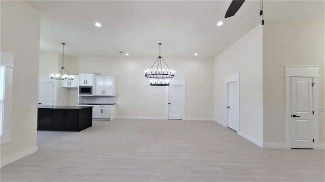 108 Tralee Ct, Yukon, OK 73099 - kitchen featuring a chandelier, stainless steel microwave, light wood finished floors, ceiling fan, and recessed lighting
