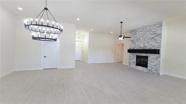 unfurnished living room with ceiling fan, a stone fireplace, and light hardwood / wood-style flooring