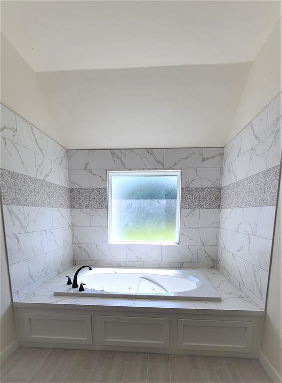 108 Tralee Ct, Yukon, OK 73099 - bathroom featuring a whirlpool tub, wood finished floors, and vaulted ceiling