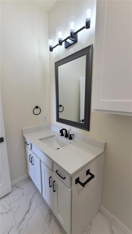 108 Tralee Ct, Yukon, OK 73099 - bathroom featuring marble look tile flooring, vanity, and baseboards