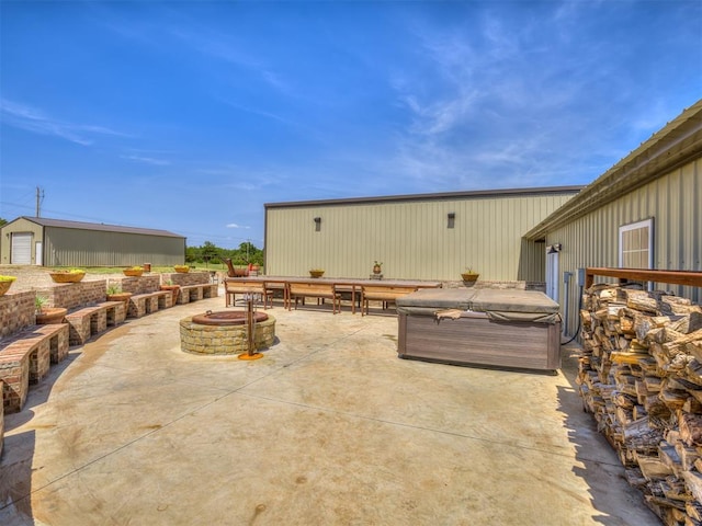 view of patio with an outdoor fire pit and a hot tub