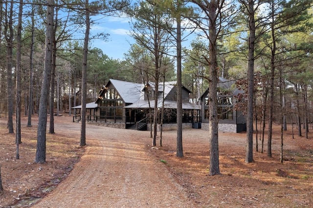 view of front of house with covered porch and dirt driveway