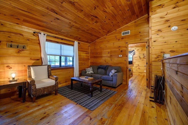 living room featuring wooden walls, light hardwood / wood-style flooring, wood ceiling, and lofted ceiling