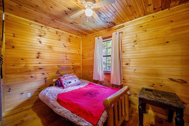 bedroom featuring hardwood / wood-style floors, ceiling fan, wooden ceiling, and wooden walls