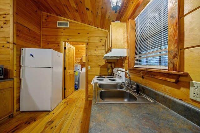 kitchen featuring white appliances, wooden walls, sink, light hardwood / wood-style floors, and lofted ceiling