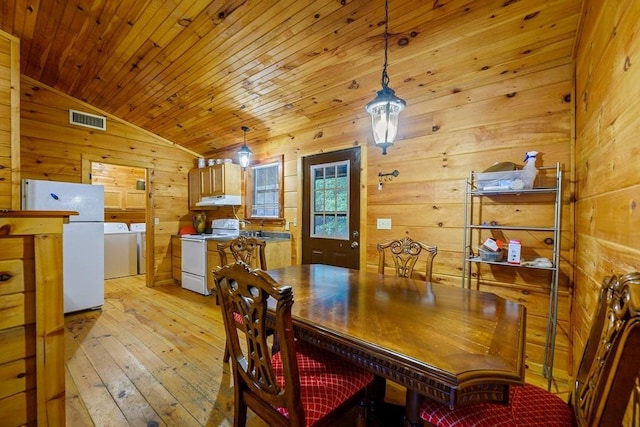 dining space with washer and dryer, wooden ceiling, light hardwood / wood-style floors, lofted ceiling, and wood walls