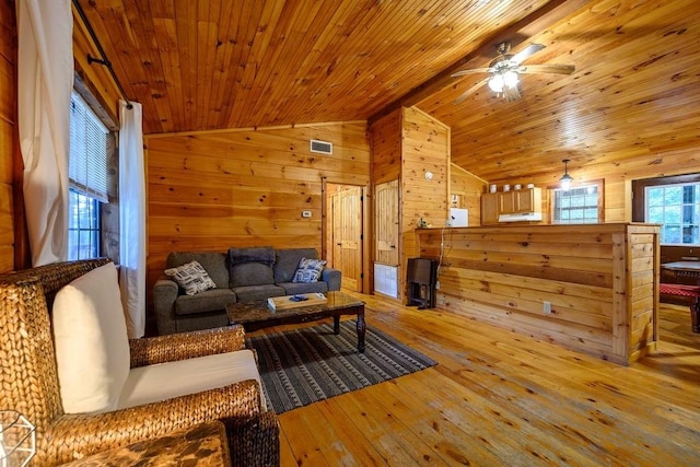 living room with ceiling fan, wooden ceiling, wood walls, lofted ceiling, and light wood-type flooring