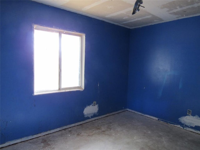 unfurnished room featuring plenty of natural light and concrete floors