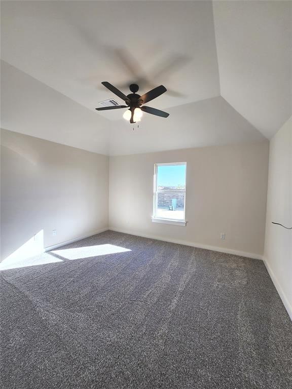 empty room with carpet, vaulted ceiling, and ceiling fan