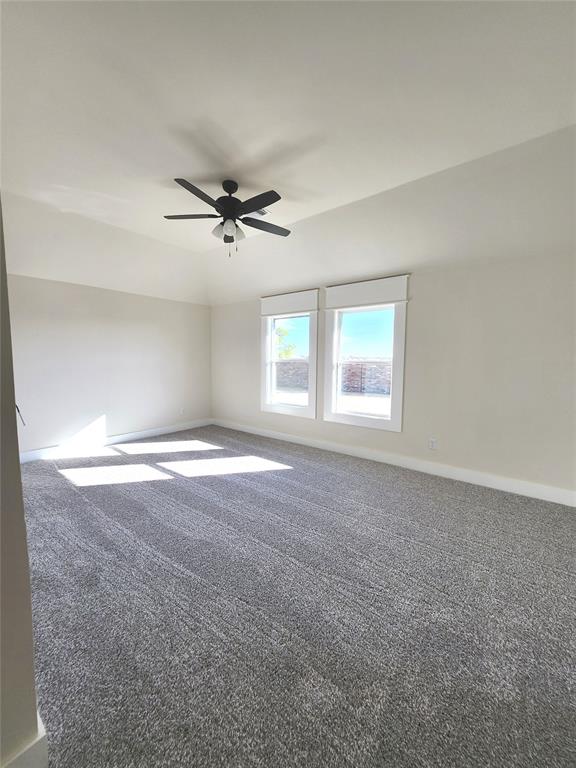 carpeted spare room featuring ceiling fan