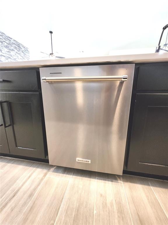 kitchen featuring ceiling fan, stainless steel dishwasher, and light wood-type flooring