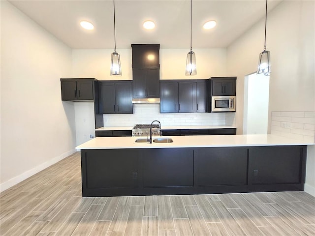 kitchen featuring hanging light fixtures, stainless steel microwave, and sink