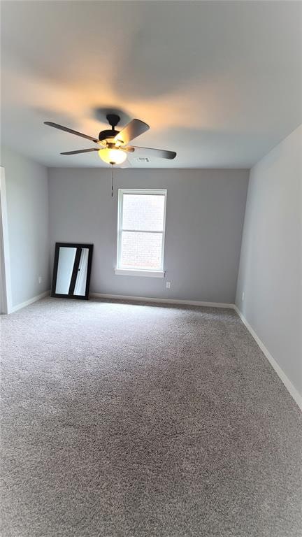 carpeted empty room featuring ceiling fan