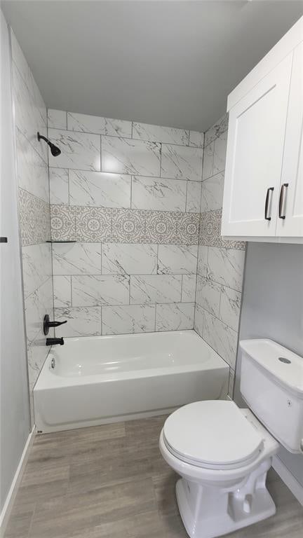 bathroom featuring hardwood / wood-style floors, tiled shower / bath, and toilet