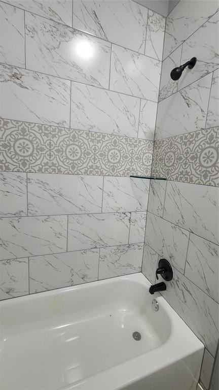 bathroom featuring tiled shower / bath