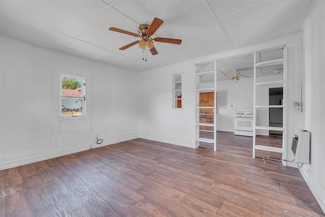 empty room featuring ceiling fan, wood-type flooring, and heating unit