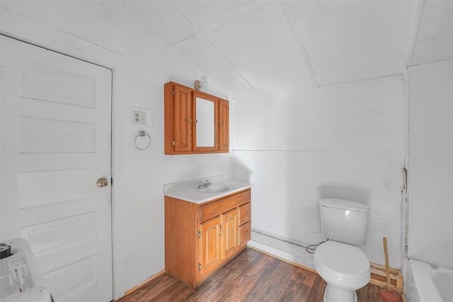 bathroom with toilet, vanity, vaulted ceiling, and hardwood / wood-style flooring