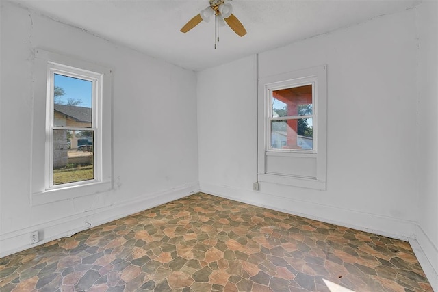 empty room featuring ceiling fan and plenty of natural light