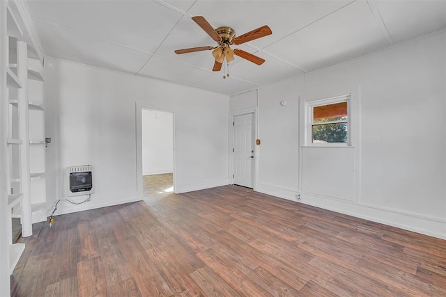 spare room featuring heating unit, ceiling fan, and hardwood / wood-style flooring