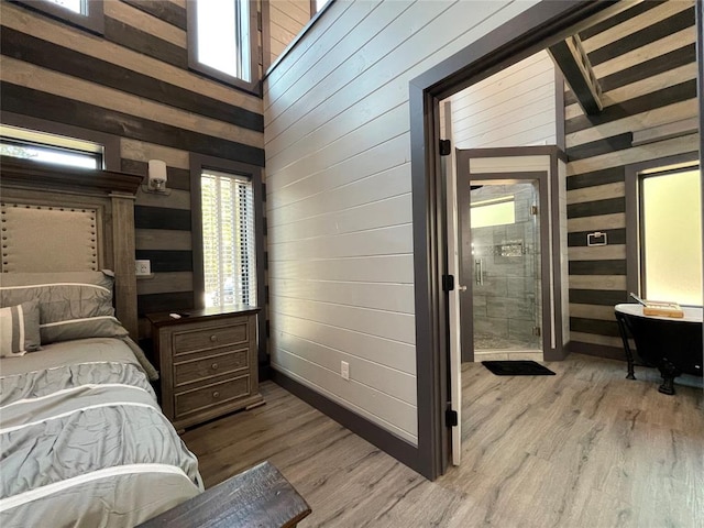 bedroom with multiple windows, wooden walls, and high vaulted ceiling