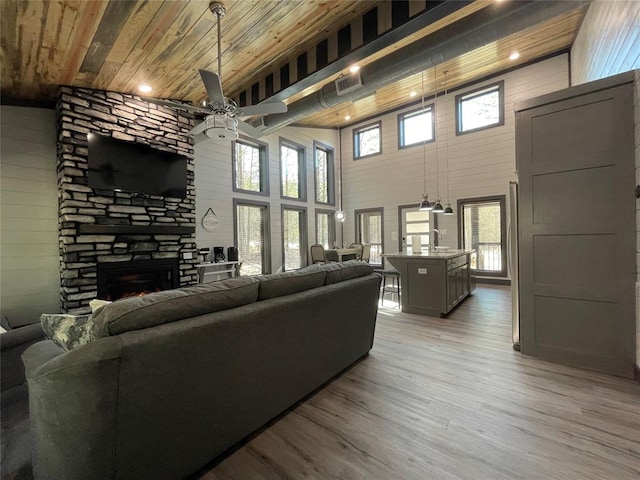 living room with plenty of natural light, wooden ceiling, a fireplace, and high vaulted ceiling