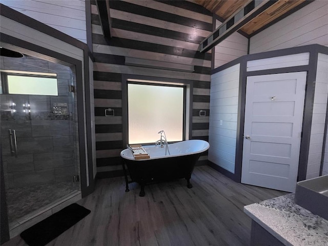 bathroom with separate shower and tub, wooden walls, hardwood / wood-style floors, and lofted ceiling with beams