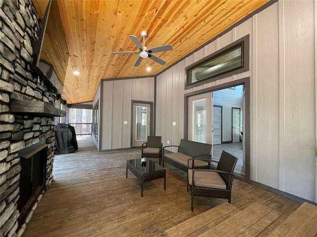 interior space with ceiling fan, wooden ceiling, vaulted ceiling, a fireplace, and hardwood / wood-style flooring