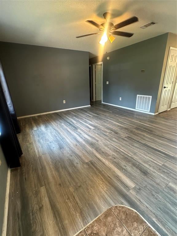 unfurnished room with ceiling fan, dark hardwood / wood-style flooring, and a textured ceiling