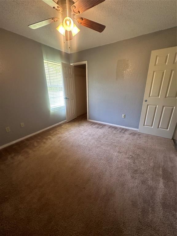 unfurnished bedroom with carpet, ceiling fan, and a textured ceiling