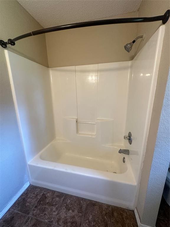 bathroom with shower / bathtub combination and a textured ceiling