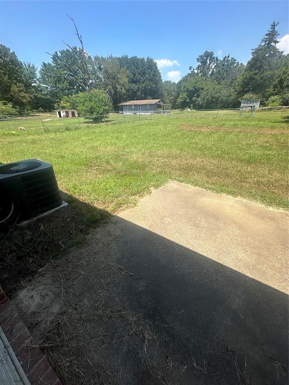 view of yard with cooling unit, a rural view, and a patio