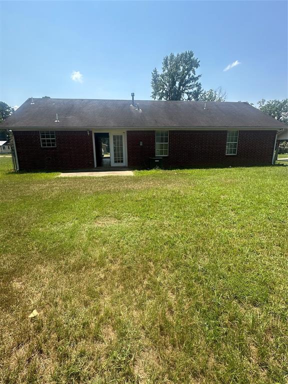 rear view of property with a yard and a patio