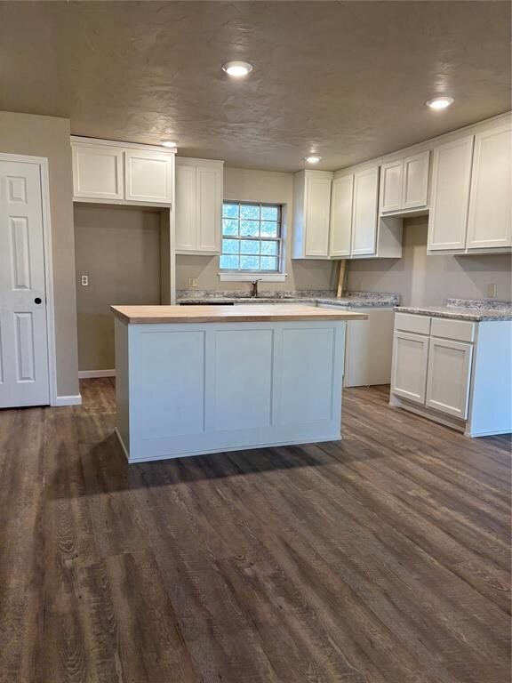 kitchen with white cabinetry, dark hardwood / wood-style flooring, and a center island